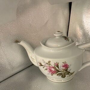 Vintage white teapot with gold accents and beautiful pink flowers